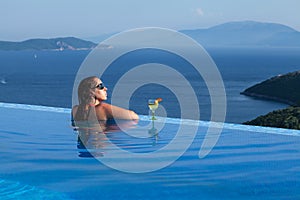 Beautiful woman is relaxing in an infinity pool