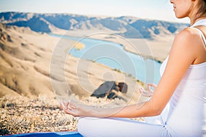 Beautiful woman relaxing and meditating outdoor at mountain