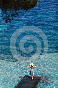 Beautiful woman relaxing on pier in Sardinia island, Italy