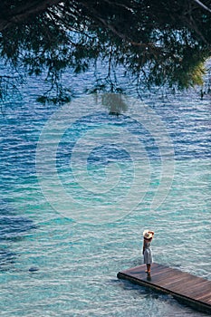 Beautiful woman relaxing on pier in Sardinia island, Italy