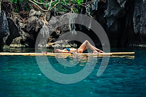 Beautiful woman relaxing on raft in tropical lagoon