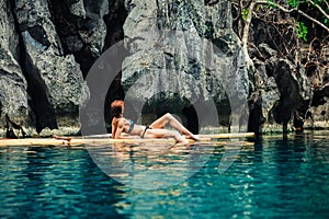 Beautiful woman relaxing on raft in tropical lagoon