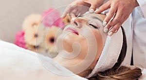 Beautiful woman relaxing during rejuvenating facial massage in a