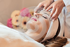 Beautiful woman relaxing during rejuvenating facial massage in a