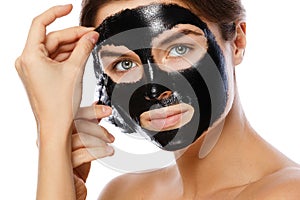 Beautiful woman is removing purifying mask from her face