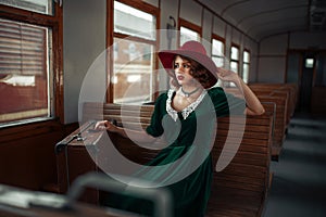 Beautiful woman in retro train, old wagon interior