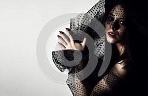 Beautiful woman with retro voile hat standing near the wall with text space