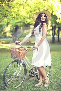 Beautiful woman riding bicycle in park and enjoying beautiful sunny day