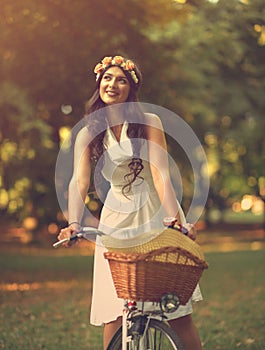 Beautiful woman riding bicycle in park and enjoying beautiful sunny day