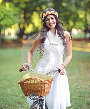 Beautiful woman riding bicycle in park and enjoying beautiful sunny day