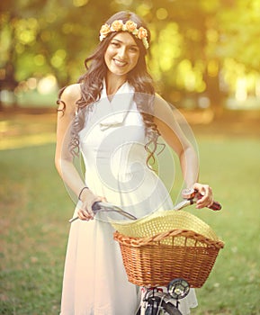 Beautiful woman riding bicycle in park and enjoying beautiful sunny day