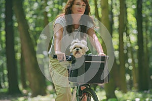 Beautiful  woman riding a bike with her dog