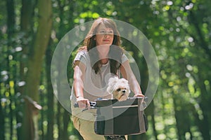 Beautiful  woman riding a bike with her dog