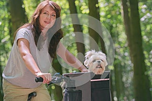 Beautiful  woman riding a bike with her dog