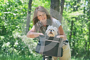 Beautiful  woman riding a bike with her dog