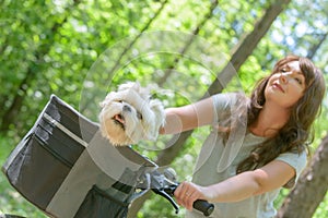 Beautiful woman riding a bike with her dog