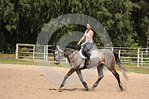 Beautiful woman riding gray horse