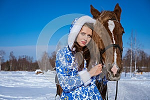 Beautiful woman riding a horse in winter on a Sunny day