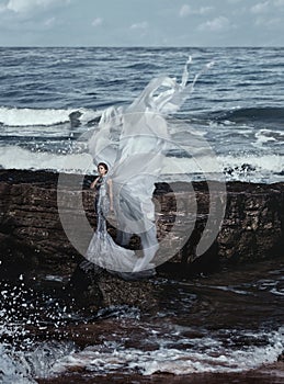Beautiful woman on a rocks near ocean background beauty portrait photoshoot
