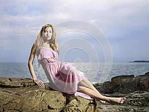 Beautiful woman on a rocky seashore