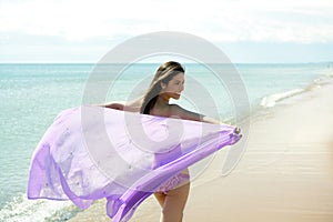 Beautiful woman running in bikini on the beach