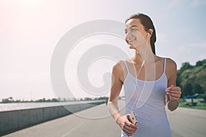Beautiful woman running during sunset. Young fitness model near seaside. Dressed in sportswear.