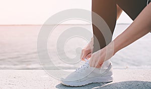 Beautiful woman running during sunset. Young fitness model near seaside. Dressed in sportswear. Cords sneakers