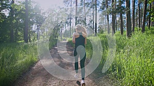 Beautiful woman running on the trail in the forest