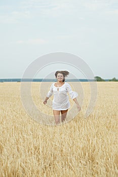 Beautiful woman running in a wheat field