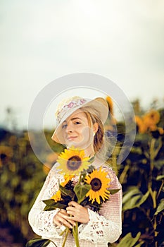 Beautiful woman in a rural field scene outdoors, with sunflowers