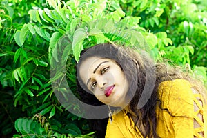 A beautiful woman`s face near defocued neem leaves