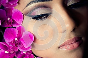 Beautiful woman's face with orchid flowers