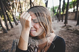 Beautiful woman`s face sobbing in disgust as she rests her head on her hand