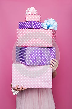 Beautiful woman's hands holding a colorful big and small gift boxes with ribbon. Soft colors. Christmas, birthday, Valentine day