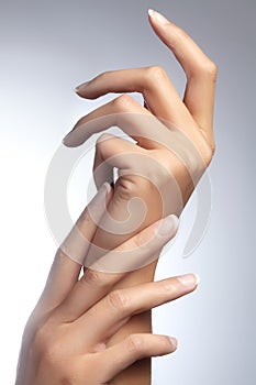 Beautiful woman`s hands on light background. Care about hand. Tender palm. Natural manicure, clean skin. French nails photo