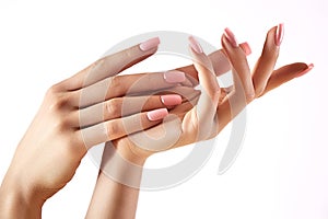 Beautiful woman`s hands on light background. Care about hand. Tender palm. Natural manicure, clean skin. Pink nails