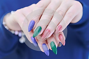 beautiful Woman\'s hands with long nails and multi-colored manicure