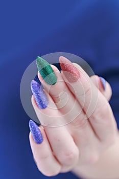beautiful Woman\'s hands with long nails and multi-colored manicure