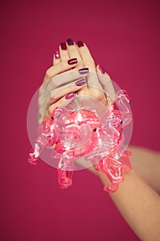 Beautiful woman`s hands with perfect pink nail polish holding flamingo lights into camera