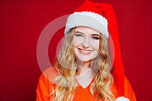 a beautiful woman in a Santa Claus hat on a red background.
