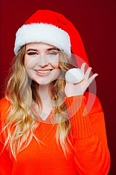 a beautiful woman in a Santa Claus hat on a red background.