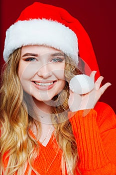 a beautiful woman in a Santa Claus hat on a red background.