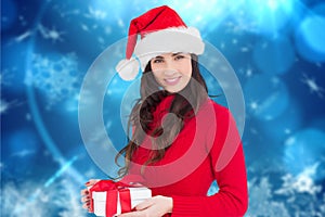 Beautiful woman in santa hat holding a christmas gift