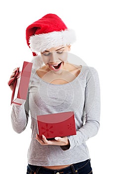 Beautiful woman in santa hat and opening present.