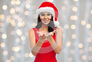 Beautiful woman in santa hat showing empty hands