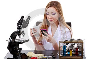 Beautiful woman scientist in laboratory with coffee speak phone