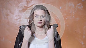 Beautiful woman screaming over orange background.