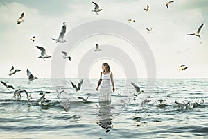 Beautiful woman and seaguls on the beach