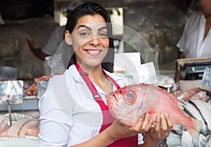 Beautiful woman selling fresh fish on a latin fish market