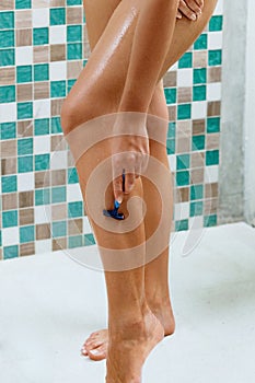 Beautiful woman is shaving her leg. Wet feet, women legs in the shower.Girl washing her legs. Skin Care.